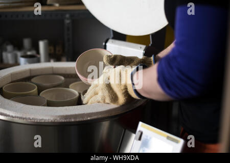 Potter, Töpfe in den Brennofen Stockfoto