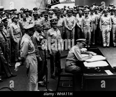 WW2: Bucht von Tokio, Japan. Fleet Admiral Chester Nimitz W Zeichen der japanischen Kapitulation Dokument an Bord der Flugzeugträger, die USS Missouri (BB-63). Auf der Suche auf der linken Seite sind: General Douglas MacArthur, Admiral William F Halsey und hinteren Admiral Forrest P Sherman. Stockfoto