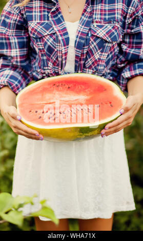 Frau mit einem Stück reife Wassermelone in ein Picknick. Herbst Ernte. Herbst Konzept. Stockfoto