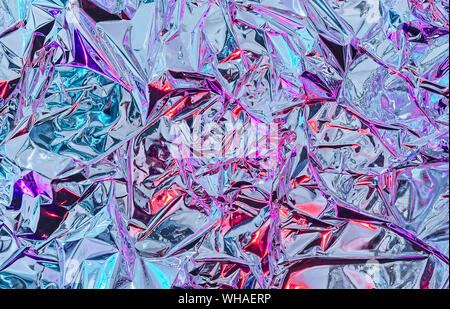 Aluminiumfolie mit mehrfarbiger Beleuchtung. Hintergrund und die Textur von Aluminium- Folie. Stockfoto