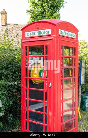 Ein defibrillator in einem alten roten Telefonzelle im Cotswold Dorf Didbrook, Gloucestershire UK untergebracht Stockfoto