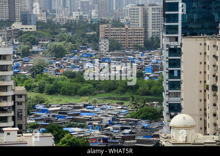 Indien, Mumbai, Stadt Wachstum, Wolkenkratzer mit teuren Wohnungen und Slum Hütten der Slumbewohner dweller Neben im Vorort Goregoan, Gesellschaft Kontrast und die Reichen und die Armen, Reichtum und Armut, Grundstück, Eigentum Stockfoto