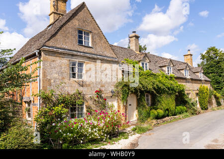 Sommer Blumen auf Cotswold Stone Cottages in der Ortschaft Holz Stanway, Gloucestershire, Großbritannien