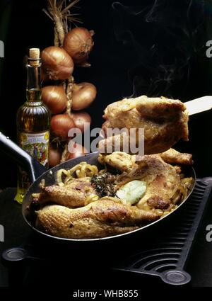 Huhn mit Zwiebeln string hängen in den Hintergrund und die Flasche James Plagniol Öl.. Stockfoto