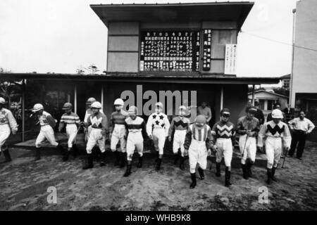 Pferderennen in Tokio, Japan: Jockeys, die herauskommen, nachdem die in wiegen Stockfoto