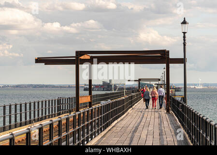 Sanierungsarbeiten werden am Southend Pier in der Themsmündung durchgeführt. Eisenbau, Beine. Leute, die auf dem Gehweg laufen Stockfoto