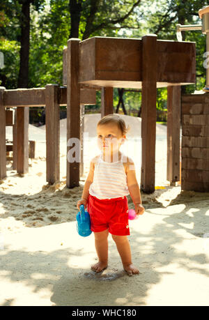 Cute kid mit Gießkanne auf einem Spielplatz Stockfoto