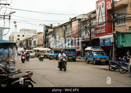 Roller fahren auf den Straßen von Phuket Altstadt. Busse sind im Hintergrund sichtbar. Stockfoto