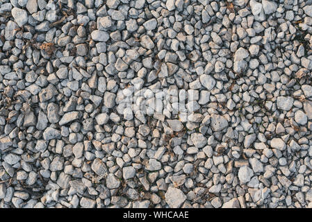 Eine Menge Kies liegt auf dem Weg in den Park. Vorbereiten der Straße für die Nivellierung. Stein Hintergrund. Stockfoto