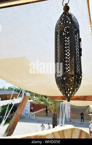 Eine typische arabische Lampe hängt. Sonnensegel für den Hintergrund. Sonnigen Tag. Stockfoto