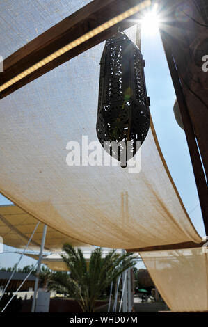 Eine typische arabische Lampe hängt. Sonnensegel für den Hintergrund. Sonnigen Tag. Stockfoto