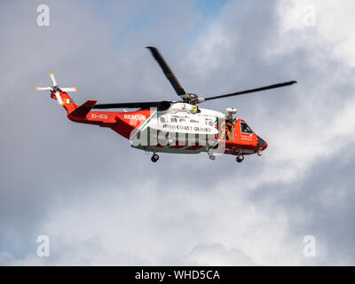 Funkwellen air show, Portrush, Nordirland, 2019. Irish Coast Guard Hubschrauber. Crew Mitglied kann gesehen werden, stehen in der Hecktür Stockfoto