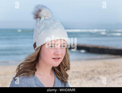 Weibliche Modell tragen weiße gestrickte Mütze mit Bluetooth Lautsprecher Stockfoto