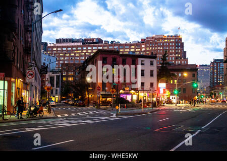 NEW YORK CITY - 24. AUGUST 2019: Street Scene mit Geschäften, Lichter, Menschen und Autos, die in der Nacht von Greenwich Village, West Village Manhattan gesehen. Stockfoto