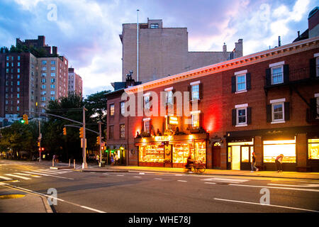 NEW YORK CITY - 24. AUGUST 2019: Street Scene mit Geschäften, Lichter, Menschen und Autos, die in der Nacht von Greenwich Village, West Village Manhattan gesehen. Stockfoto