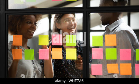Fröhlich multikulturellen Geschäftsleute Spaß Planung Projekt auf Haftnotizen Stockfoto