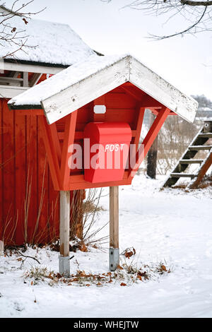 Alte vintage rot Holz- mail Post Box in der Landschaft Dorf im Winter. Stockfoto