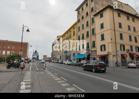 LIVORNO, Italien - 11 Juli, 2019: Stadtbild mit Menschen entlang San Giovanni Strasse. Alte Festung und Hafen mit festgebundenen Kreuzfahrtschiff der backgrou Stockfoto