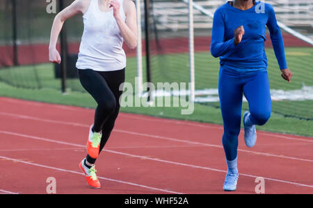 Zwei High School Mädchen, spandex an Ihre Beine suring ein Rennen, weil es Frühling ist und kalt. Stockfoto