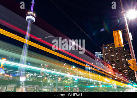 Eine lange Exposition von Toronto in der Nähe des CN Tower bei Nacht mit Straßenbahn leichte Wanderwege. Stockfoto