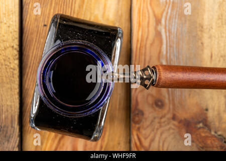 Alte stilvolle Kalligraphie Feder und Tinte auf einem Holztisch. Schreiben Zubehör für Arbeit vorbereitet. Der dunkle Hintergrund. Stockfoto