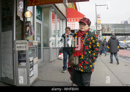 Eine Straßenszene in Chinatown, Königinnen mit einem farbenfroh gekleideten Frau mittleren Alters. New York City. Stockfoto
