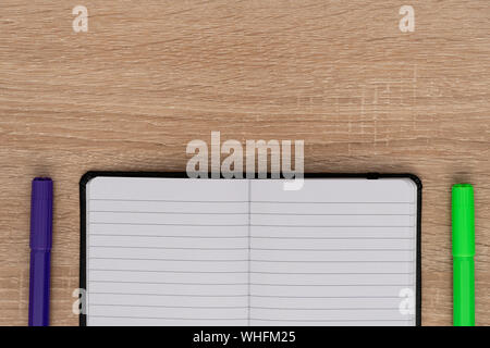 Notebook mit farbigen Markierungen auf hölzernen Schreibtisch Stockfoto