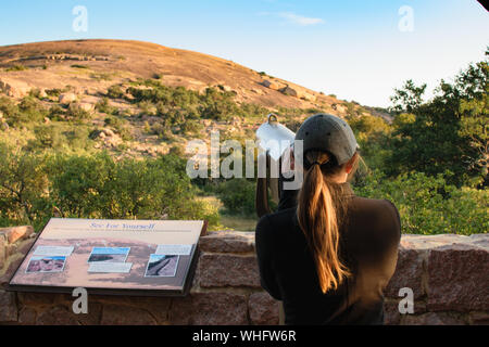 Frau Suchen Münze Teleskop auf eine Beobachtung Schreibtisch betrieben Stockfoto