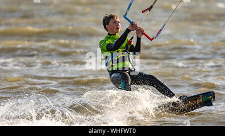 Man Kitesurfen im Meer in Llanelli Strand, Carmarthenshire, Wales. UK. Stockfoto