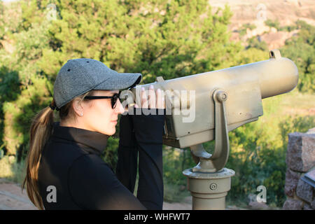 Frau Suchen Münze Teleskop auf eine Beobachtung Schreibtisch betrieben Stockfoto