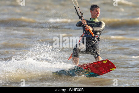 Man Kitesurfen im Meer in Llanelli Strand, Carmarthenshire, Wales. UK. Stockfoto