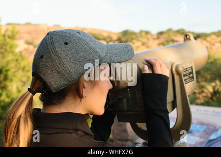 Frau Suchen Münze Teleskop auf eine Beobachtung Schreibtisch betrieben Stockfoto