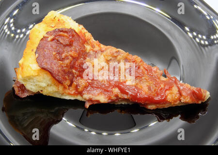 Pizza Schnitten auf einer schwarzen Platte. Pizza auf schwarzem Teller. Stockfoto