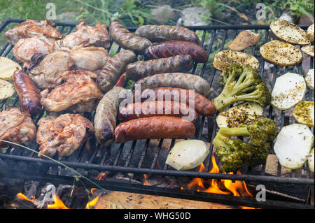 Gebratene Würstchen mit Gemüse auf dem Grill. Gesundes Essen. Gegrilltes, Essen auf dem Grill vom Feuer, Fleisch vom Grill Stockfoto
