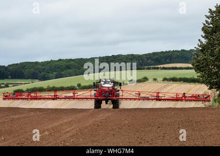 Traktor mit Feldspritze befestigt Spritzen ein Feld in der Nähe von Kelso, Scottish Borders. Stockfoto