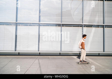 Junge schwarze afro-amerikanischer Mann außerhalb reiten Skateboard Stockfoto
