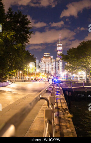 NEW YORK CITY - 24. AUGUST 2019: Blick auf die Skyline von Lower Manhattan gegenüber dem World Trade Center Tower bei Nacht mit Beleuchtung gesehen von Do Stockfoto