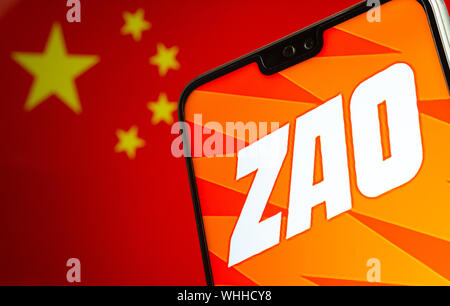 ZAO app-Logo auf dem Bildschirm des Smartphones und den unscharfen Flagge von China auf dem Bildschirm hinter sich. Zao ist derzeit einer Zahl eine unterhaltsame App in China. Stockfoto
