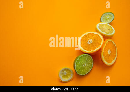 Ganze orange, in Scheiben schneiden und eine Hälfte der Orange auf ogange Hintergrund für Border Design mit Kopie Platz für Text isoliert Stockfoto