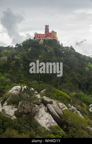 Blick auf die farbenfrohe Burg des Schlosses Pena Palace (Palácio da Pena) aus dem 19. Jahrhundert vom Schloss der Mauren in Sintra, Portugal. Stockfoto