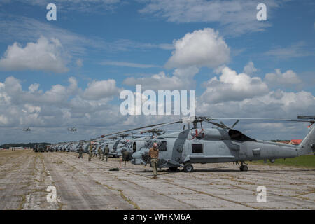 Seeleute sichere U.S. Navy MH-60R Sea Hawk Hubschrauber nach Maxwell Air Force Base, Alabama anreisen, von der Naval Air Station Jacksonville und Naval Station Mayport, Florida, Sept. 1, 2019. Die Hubschrauber vom Jacksonville Bereich im Vorfeld des Hurrikans Dorian evakuiert. Zusätzlich zu den Hubschraubern, Maxwell AFB dient als Incident Support Base für Federal Emergency Management Agency und Defense Logistics Agency Personal und Ausrüstung. (U.S. Air Force Foto von Billy Birchfield) Stockfoto