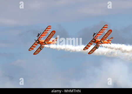 Die Breitling Wingwalkers mit ihren 1940 Doppeldecker und die Jungen Damen auf der Oberseite gegurtet Wimmern die Masse an der Eastbourne International Airshow 2017. Stockfoto