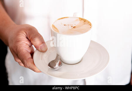 Cappuccino Tasse mit schönen Milchschaum in der Frau hand Nahaufnahme Stockfoto