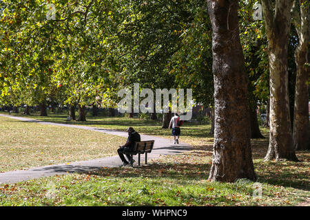 London, Großbritannien. 02 Sep, 2019. Ein Mann genießt Herbst Sonnenschein in Nord London Park mit der gefallenen Blätter im Herbst fallen. Credit: SOPA Images Limited/Alamy leben Nachrichten Stockfoto