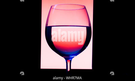 Glas oder Gläser mit Alkohol, Wein, Whisky, Gin, Bier, Rum, Wodka, Whisky, Cognac, Brandy, Likör, Absinth oder Cocktail auf rosa Hintergrund. Ein Glas an der Bar Stockfoto