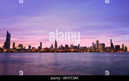 Panoramablick auf die Skyline von Chicago in der Dämmerung mit dem Michigan See im Vordergrund, IL, USA Stockfoto