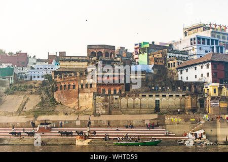 Atemberaubende Aussicht auf die Stadt Varanasi mit bunten Häusern und Gebäuden über ein Ghat durch die heiligen Ganges gebadet. Stockfoto