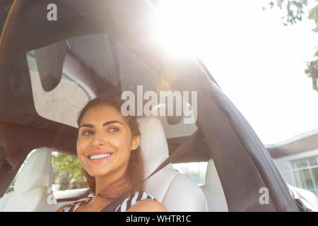 Dark-eyed Frau genießen Sie fahren an einem schönen sonnigen Tag Stockfoto