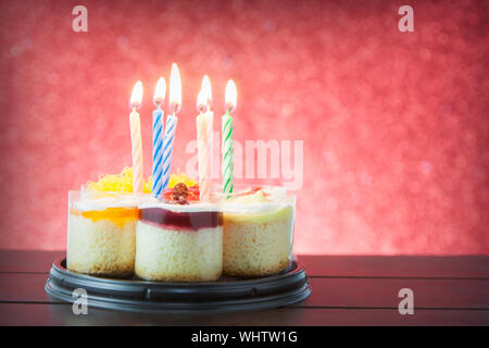 Geburtstag Kuchen mit Kerzen auf farbigen Hintergrund Stockfoto