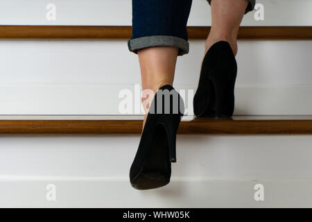 Mädchen mit Heels und jeand auf der Treppe hinauf Stockfoto